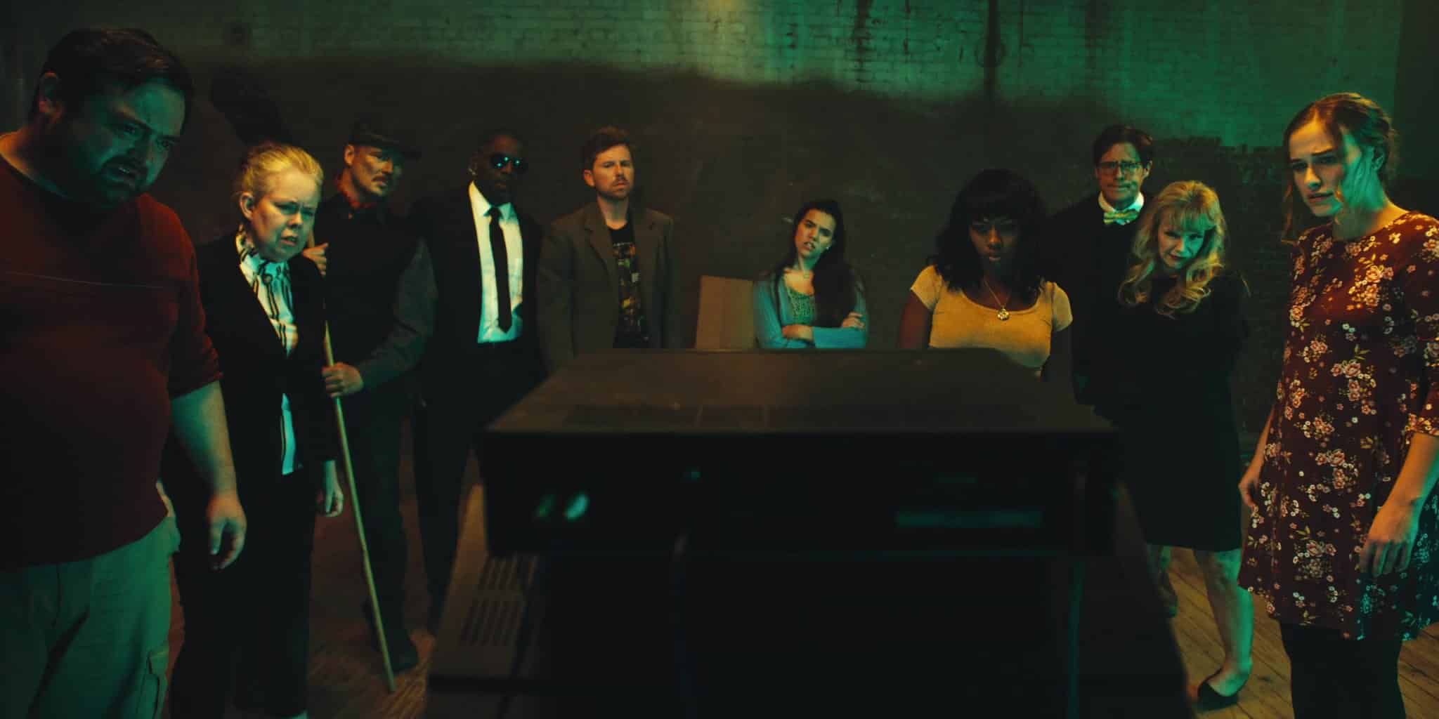 Scare Package II (2022) - A group of people surrounding an old television
