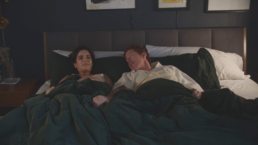 Karen the Beauty Queen Butcher (2026) - Karen lying in bed with her husband, unhappily married