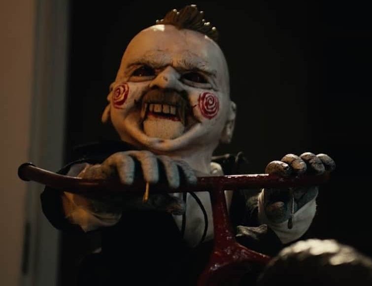 Scare Package II: Rad Chad's Revenge (2022) 2 Scare Package II (2022) - A creepy puppet on a bike resembling Billy from the Saw Franchise