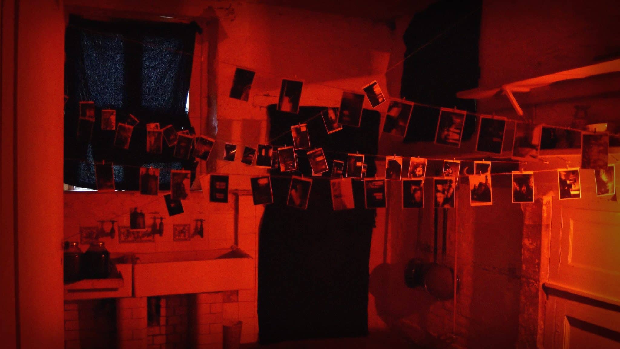 #31DaysofHalloween - Shutter (2004) - A foreboding image of a darkroom with pictures drying